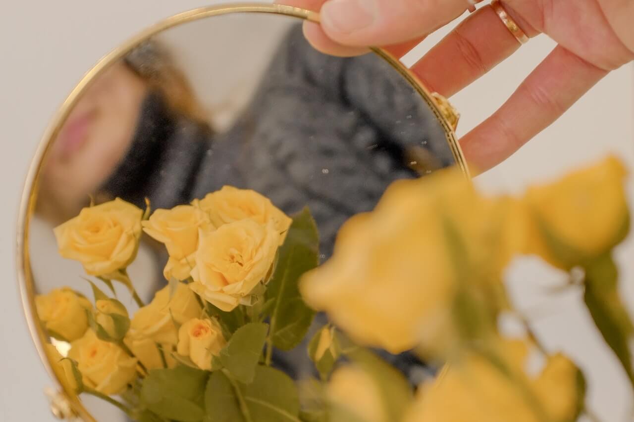 Woman looking herself in mirror