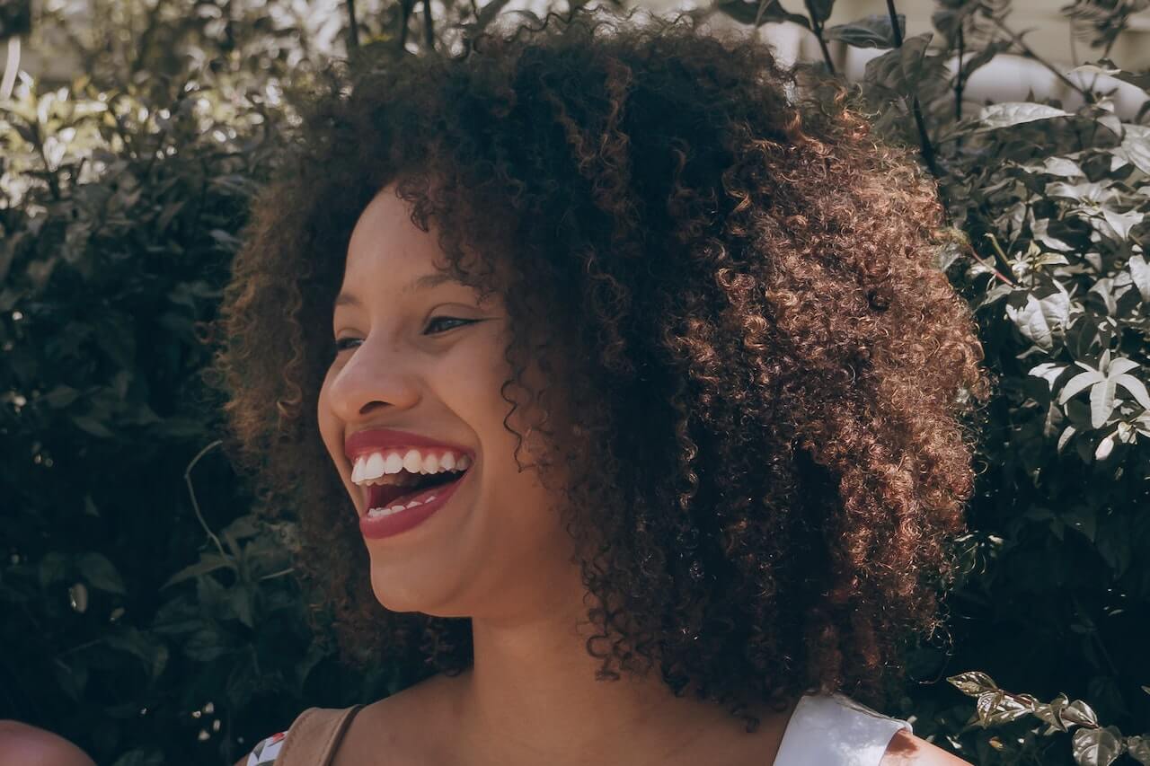 woman with coily hair smiling