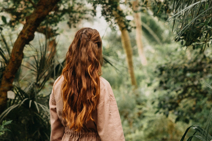 Woman with long red hair in nature