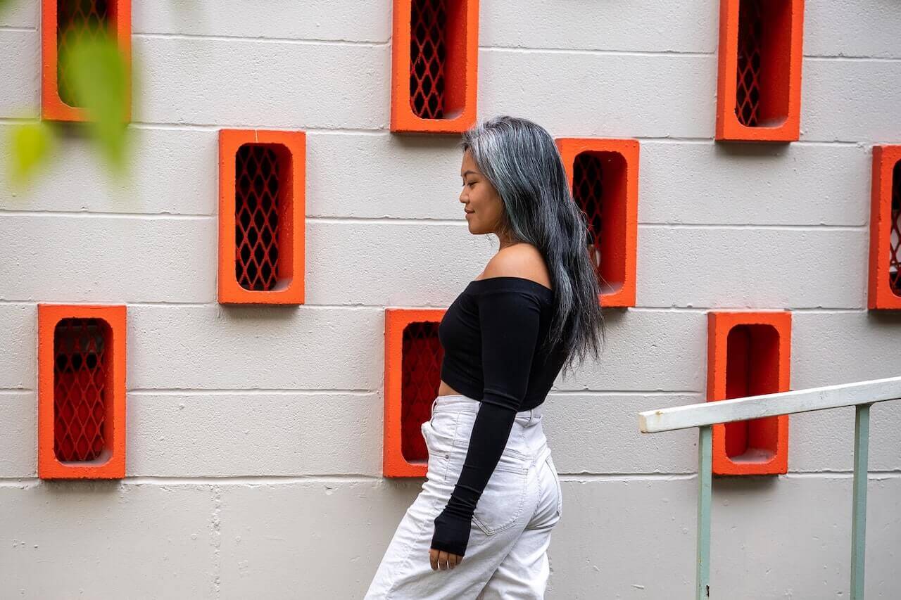 Woman with gray hair standing in front of building