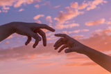 hands reaching for each other at sunset