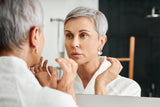 Woman with gray hair looking in the mirror