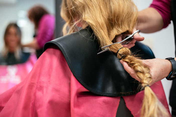 Woman cutting hair to donate