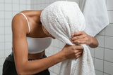 Woman drying hair with a towel