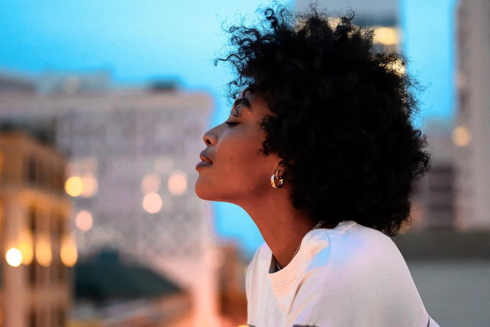 Black woman with afro overlooking the city