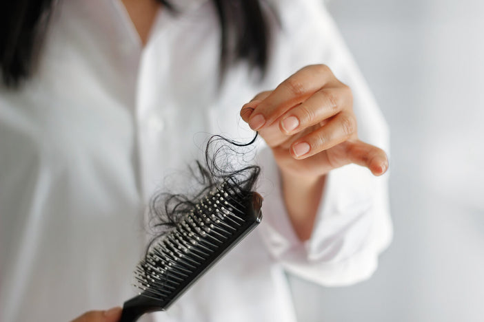 Woman pulling hair out of hair brush