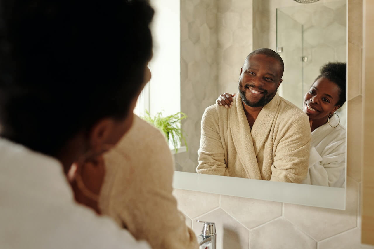 Man and woman looking at reflection in a mirror