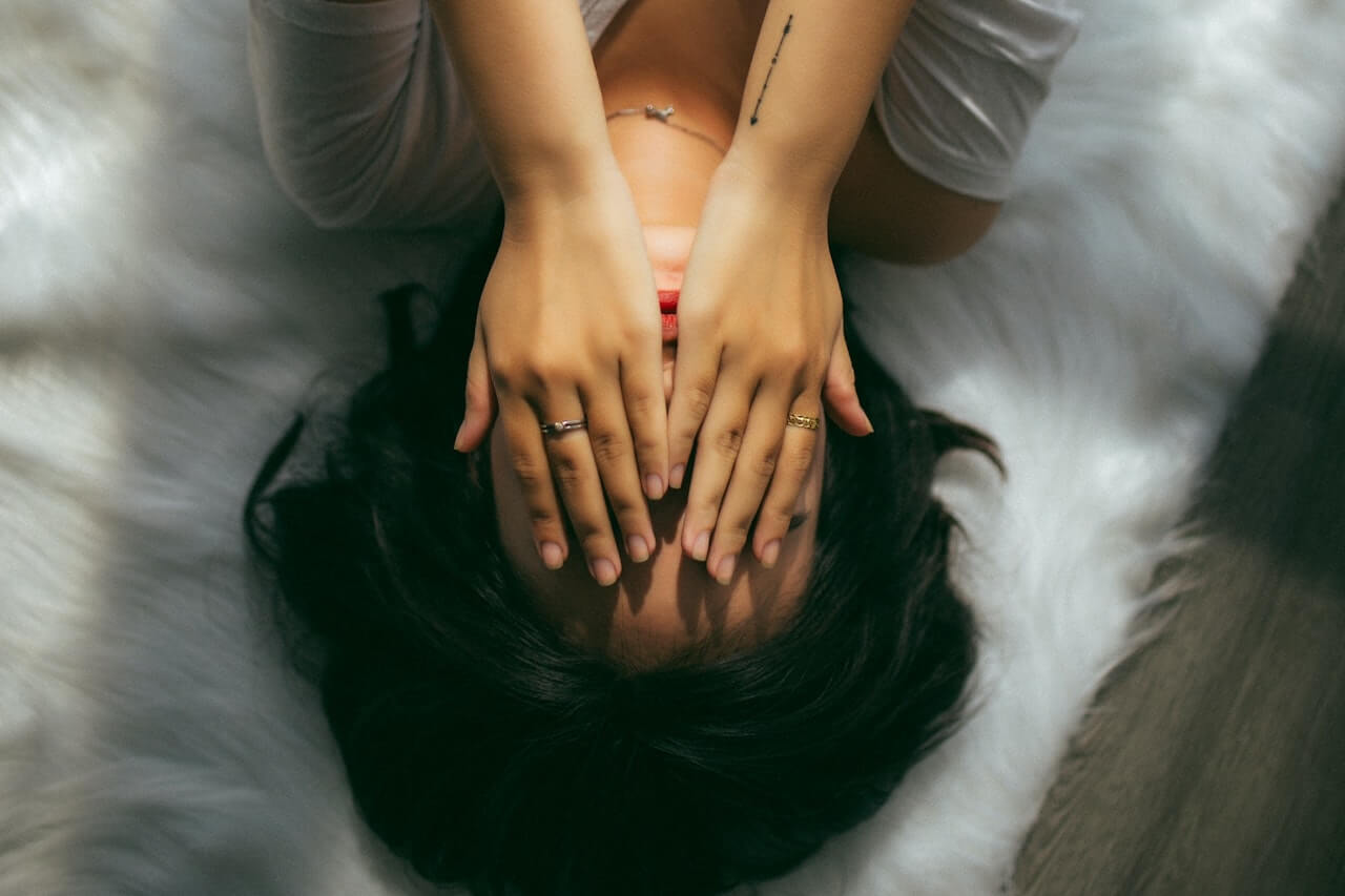woman with hands covering her face