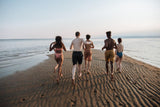 Group of people running on the beach