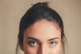 woman with thick eyebrows, brown hair and blue eyes