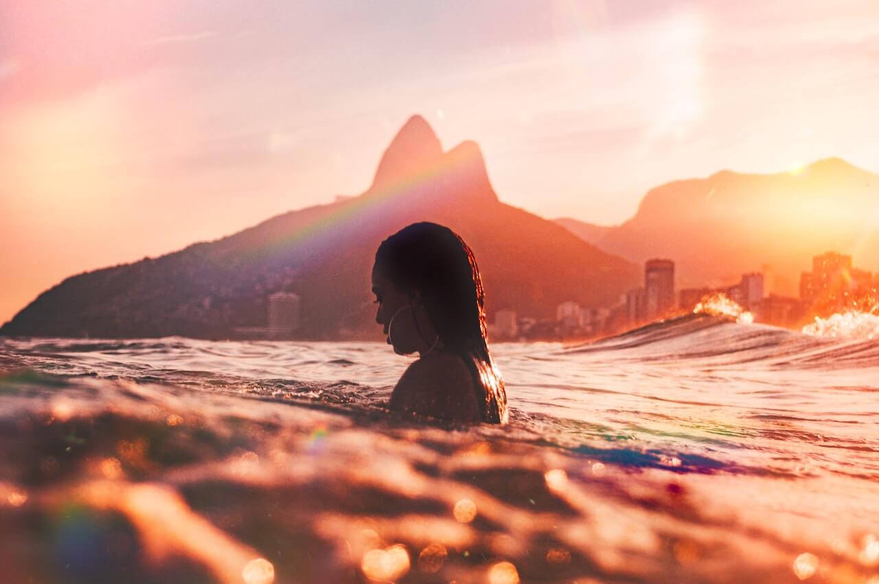 Woman swimming in the ocean at sunset
