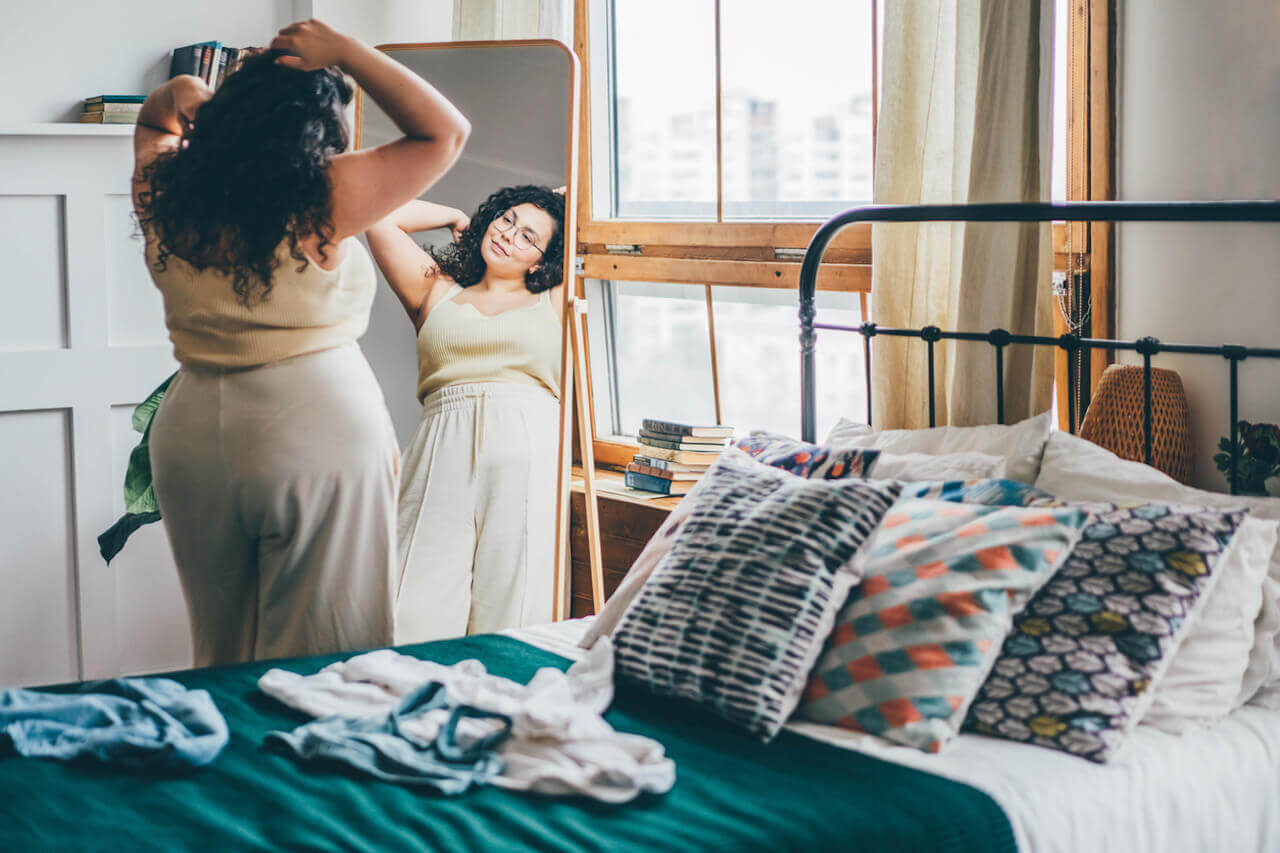 Woman scratching her head and looking in the mirror