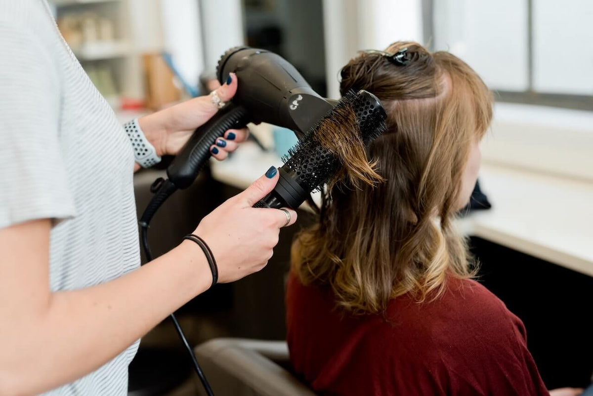 Woman getting her hair blow dried at salon