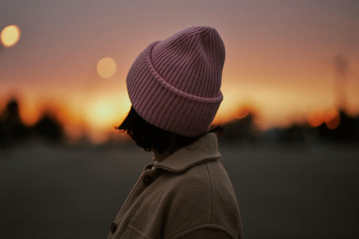 Woman wearing a beanie at sunset