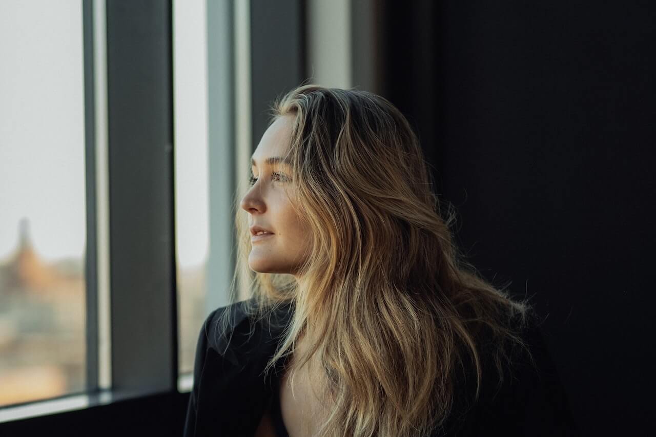 Blonde woman staring out the window