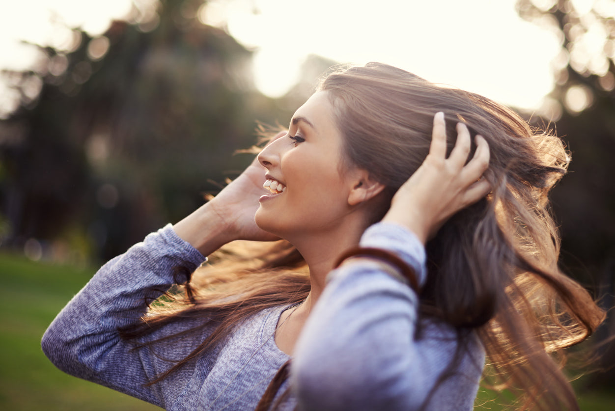 woman holding her hair as she turns her head