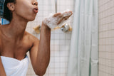 Woman blowing bath bubbles