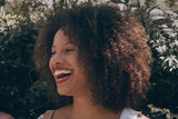 woman with coily hair smiling