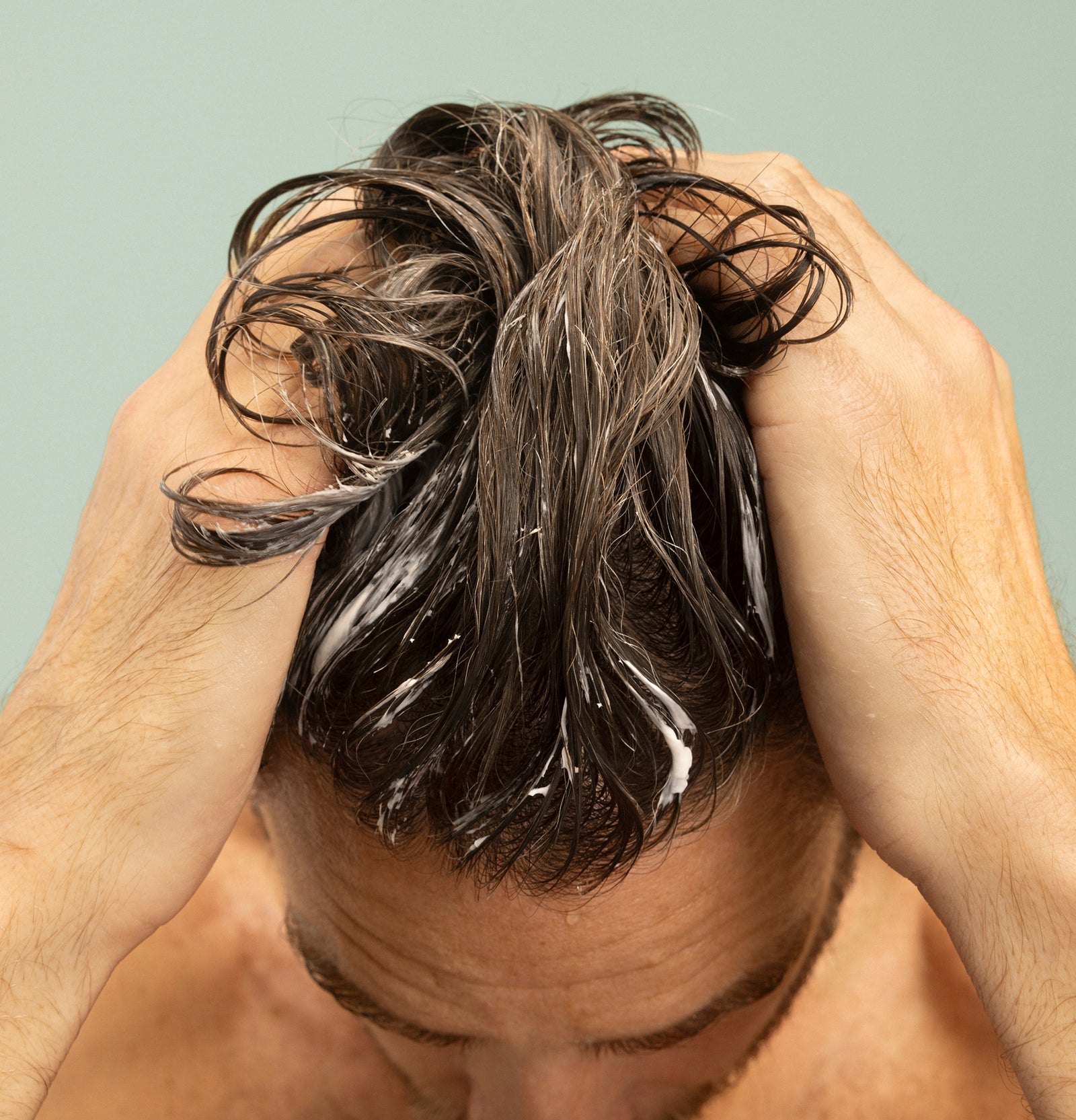 A dermatologist applying a scalp treatment to a patient's hair